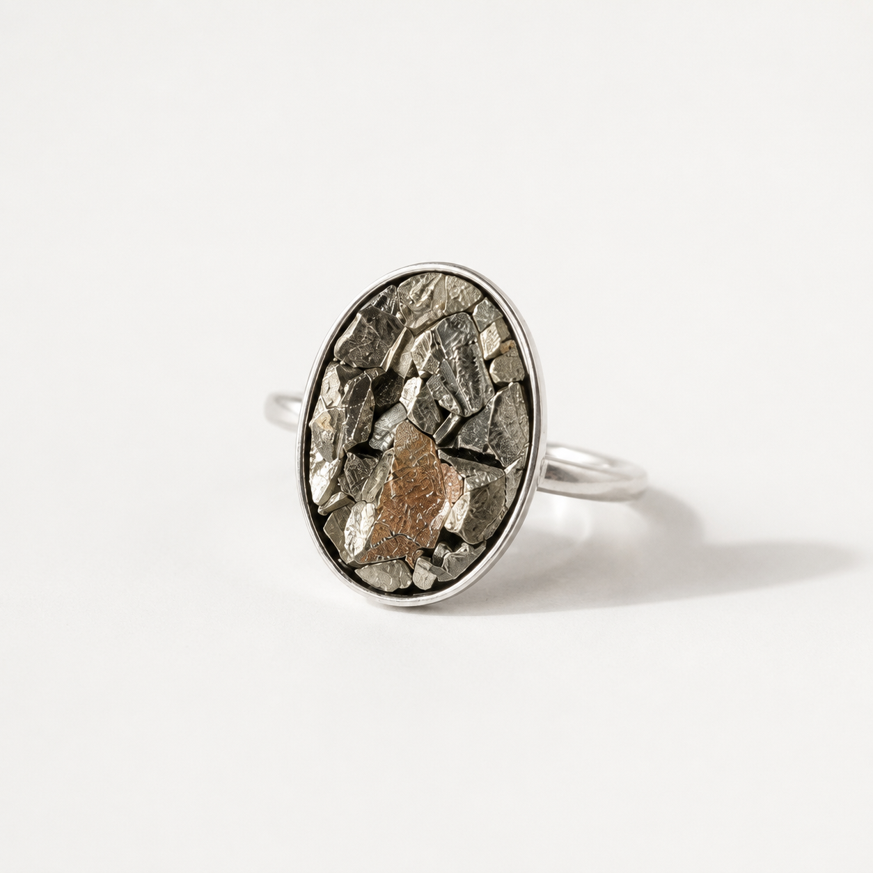 Silver pyrite ring with a textured oval stone on a white background