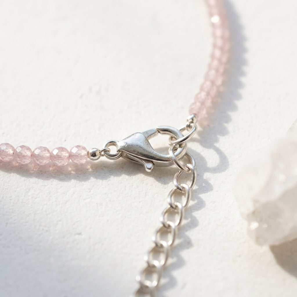 Close-up of a pink beaded bracelet with a silver clasp on a light background
