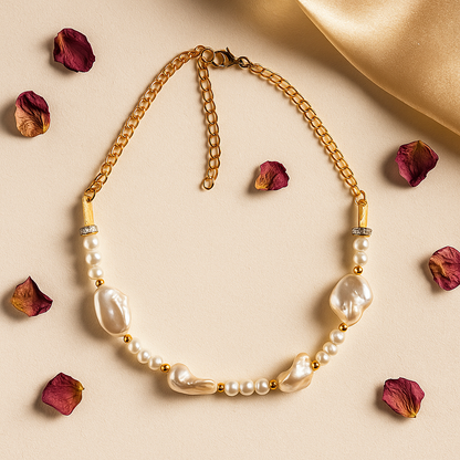 Gold necklace with pearls on a beige background with dried roses