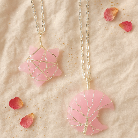 Two pink pendant necklaces with geometric designs on a beige surface with red rose petals.