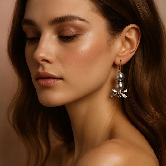 Close-up of a woman wearing a silver earring with pearls against a neutral background