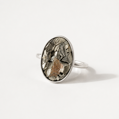 Silver pyrite ring with a textured oval stone on a white background