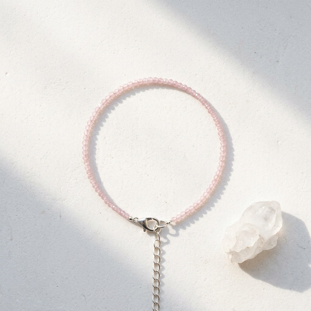 Pink beaded necklace with a silver chain on a light background