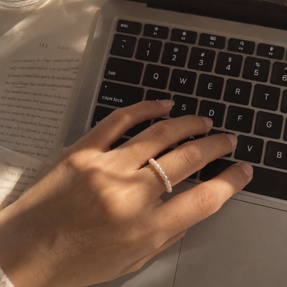 Hand with a ring typing on a laptop keyboard