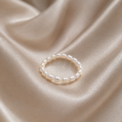 Pearl ring on a beige satin fabric